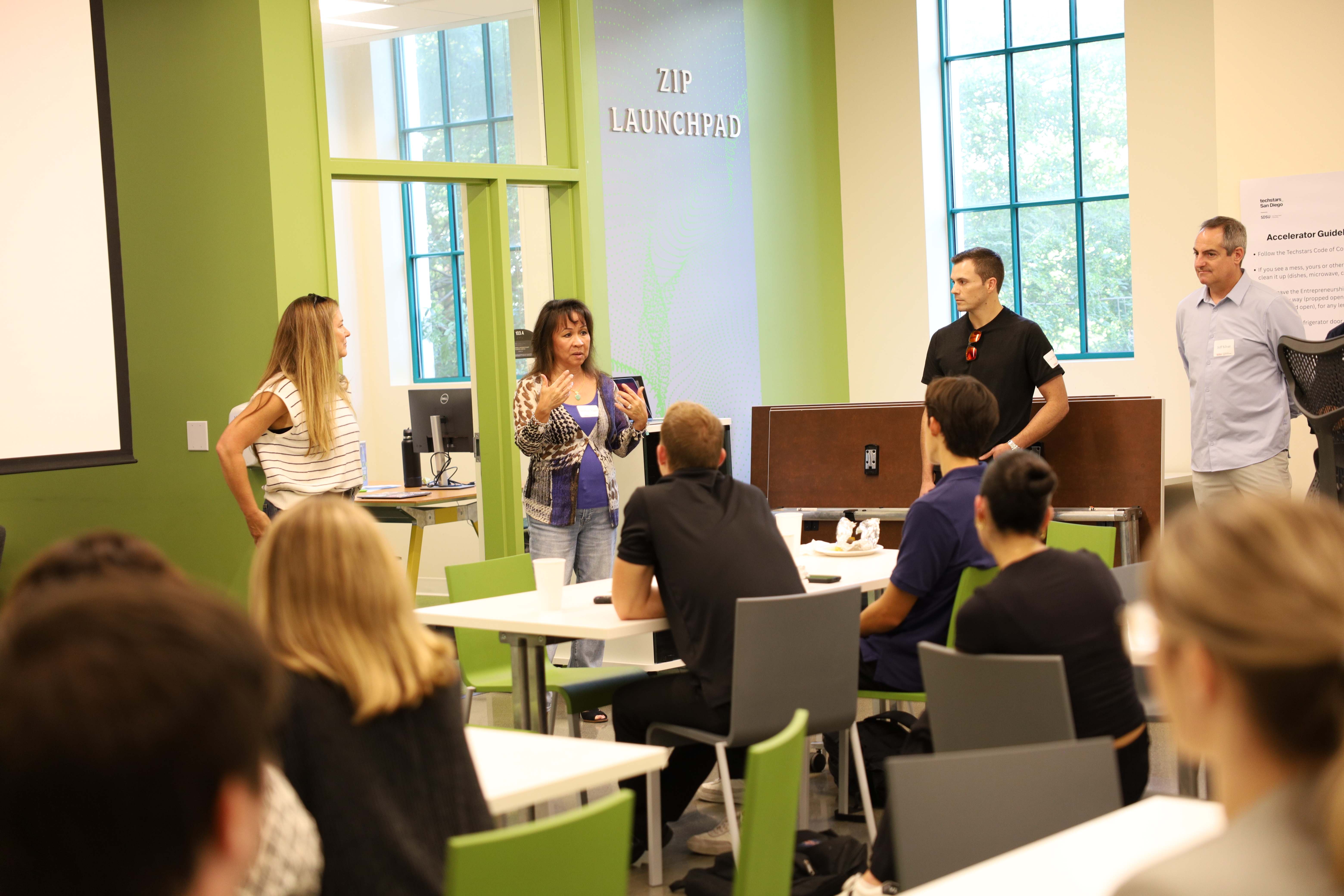 Mentors inside a green room speaking to students